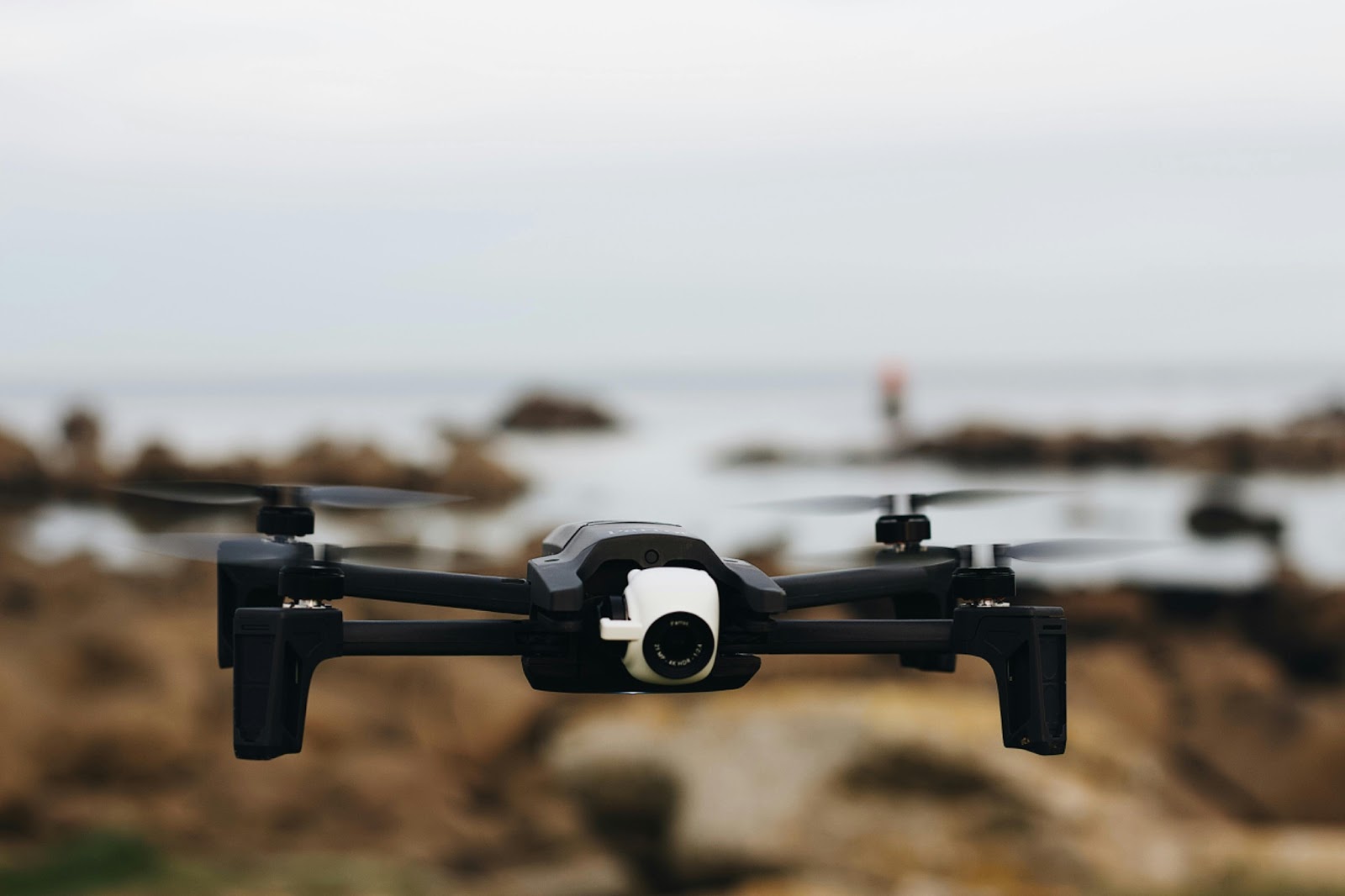 A multi-rotor quadcopter drone hovering over a construction site for detailed inspection and monitoring
